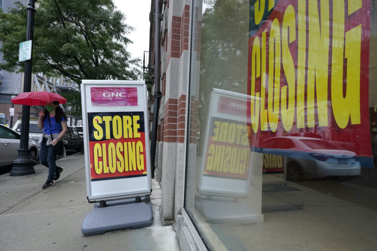 In this Sept. 2, 2020, file photo, a passerby walks past a business storefront with store closing signs in Boston. (AP Photo/Steven Senne)