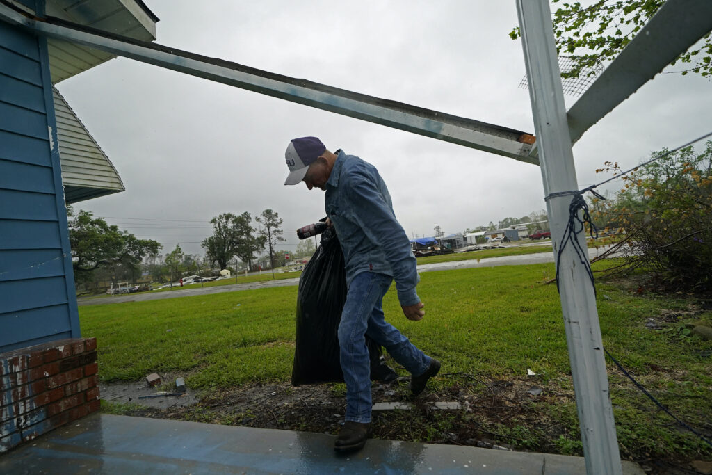 Tropical Weather Louisiana Jim Fontenot carries possessions into his brother's home, to which his family temporarily relocated to ride out Hurricane Delta which is expected to make landfall later in the day, in Lake Charles, La., Friday, Oct. 9, 2020. (AP Photo/Gerald Herbert)