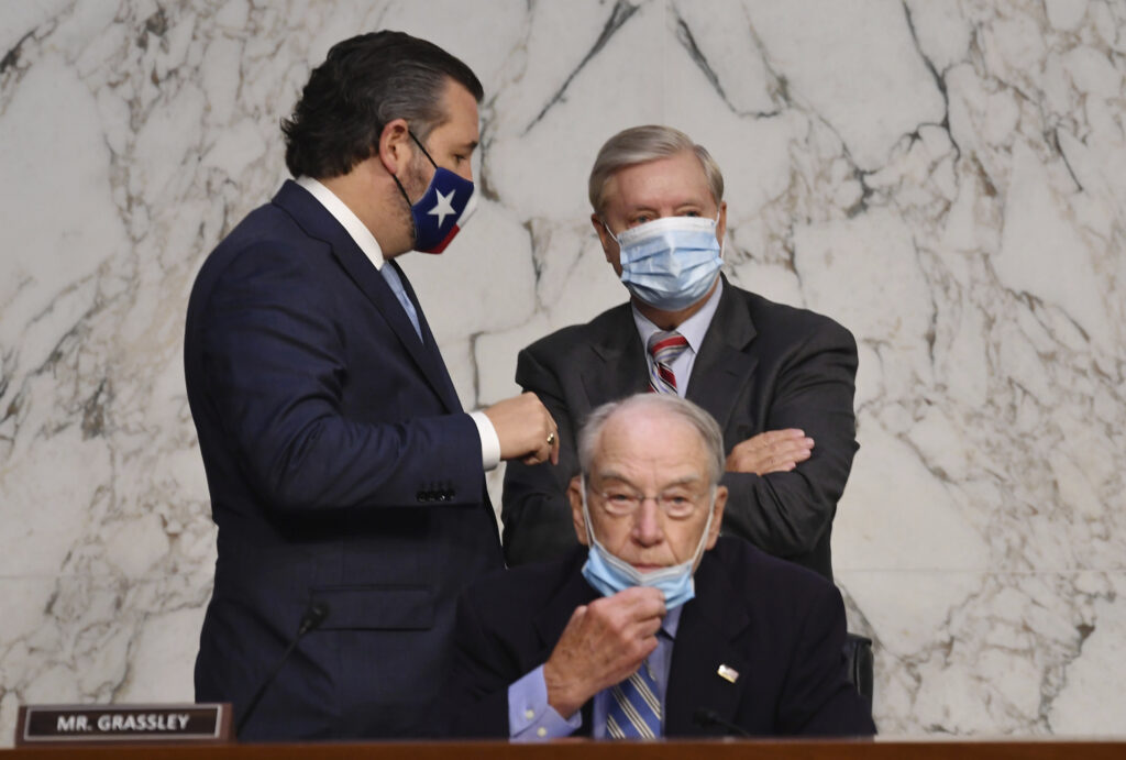 APTOPIX Supreme Court Barrett Committee Chairman Sen. Lindsey Graham, R-S.C., stands with Sen. Ted Cruz, R-Texas, left, in front of Sen. Chuck Grassley, R-Iowa, during the confirmation hearing for Supreme Court nominee Amy Coney Barrett, before the Senate Judiciary Committee, Thursday, Oct. 15, 2020, on Capitol Hill in Washington. (Kevin Dietsch/Pool via AP)