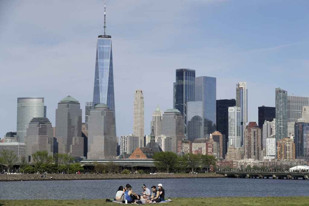Virus Outbreak New York In this Saturday, May 2, 2020 file photo, people sit in view of Lower Manhattan at Liberty State Park in Jersey City, N.J. (AP Photo/Seth Wenig)