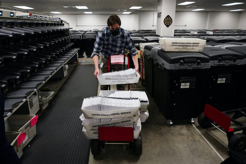 Election 2020 Pennsylvania Mail-in Voting Michael Imms, with Chester County Voter Services, gathers mail-in ballots after being sorted for the 2020 General Election in the United States, Friday, Oct. 23, 2020, in West Chester, Pa. (AP Photo/Matt Slocum)