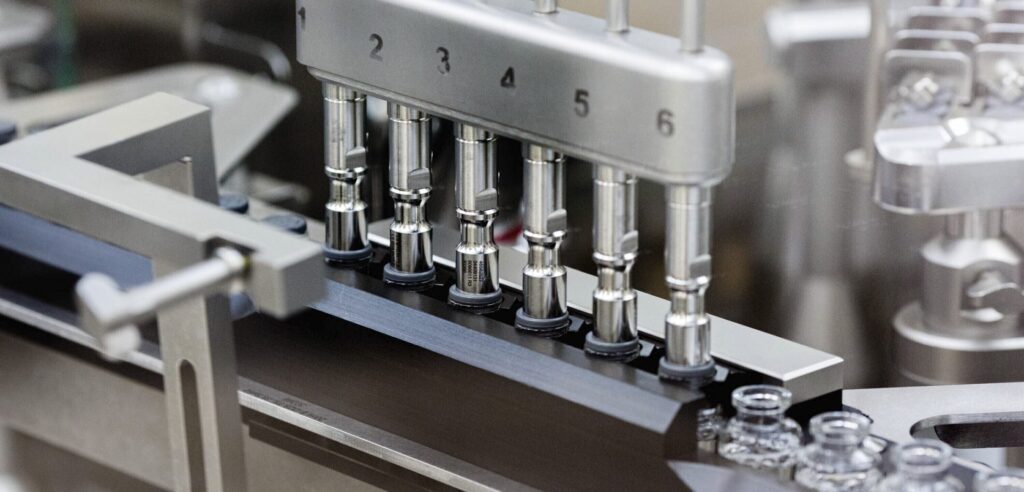 AP_20121718137562-e1589042567826-1920×922 In this March 2020 photo provided by Gilead Sciences, rubber stoppers are placed onto filled vials of the investigational drug remdesivir at a Gilead manufacturing site in the United States. (Gilead Sciences via AP)
