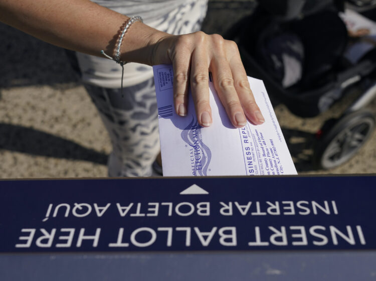 A woman deposits her ballot in an election drop box in Jersey City, N.J.