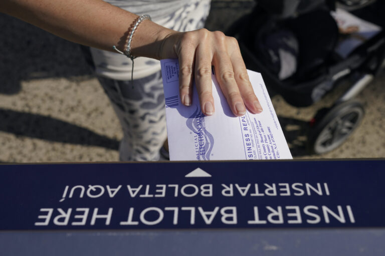 A woman deposits her ballot in an election drop box in Jersey City, N.J.