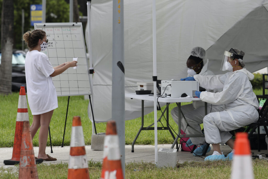 Virus Outbreak Health care workers take information from people in line at a walk-up COVID-19 testing site