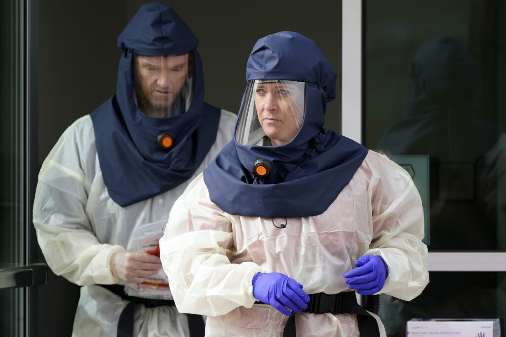 Virus Outbreak US Surge Public health nurses look on during coronavirus testing