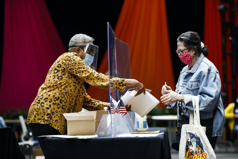 A voter checks in with an election worker before casting her ballot