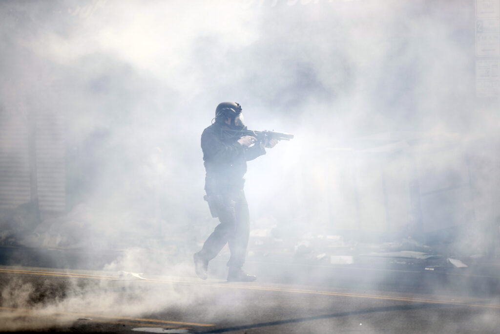 A police officer moves through tear gas deployed to disperse a crowd as Justice for George Floyd Philadelphia protests continue in Philly