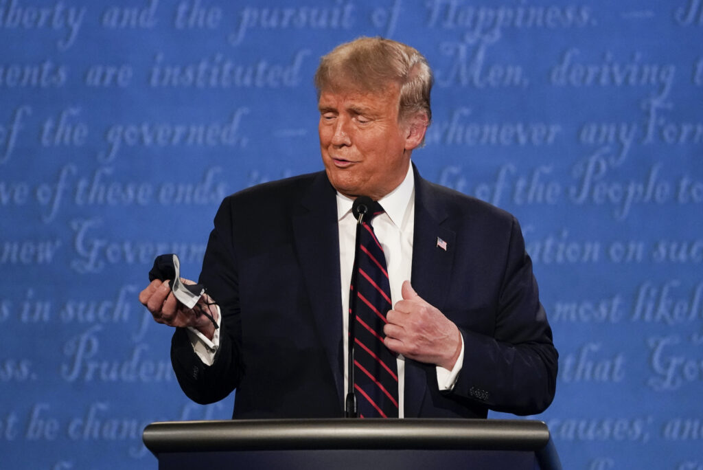President Donald Trump holds out his face mask during the first presidential debate President Donald Trump holds out his face mask during the first presidential debate