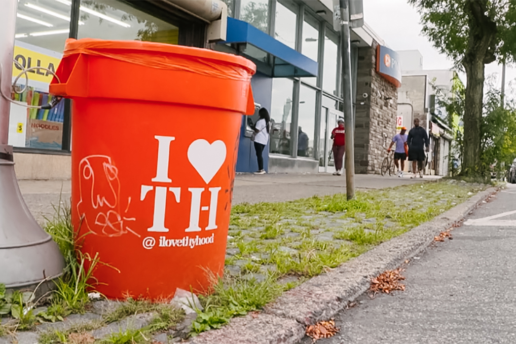 ILTH_YOK4x6 I Love Thy Hood branded trash can on a sidewalk
