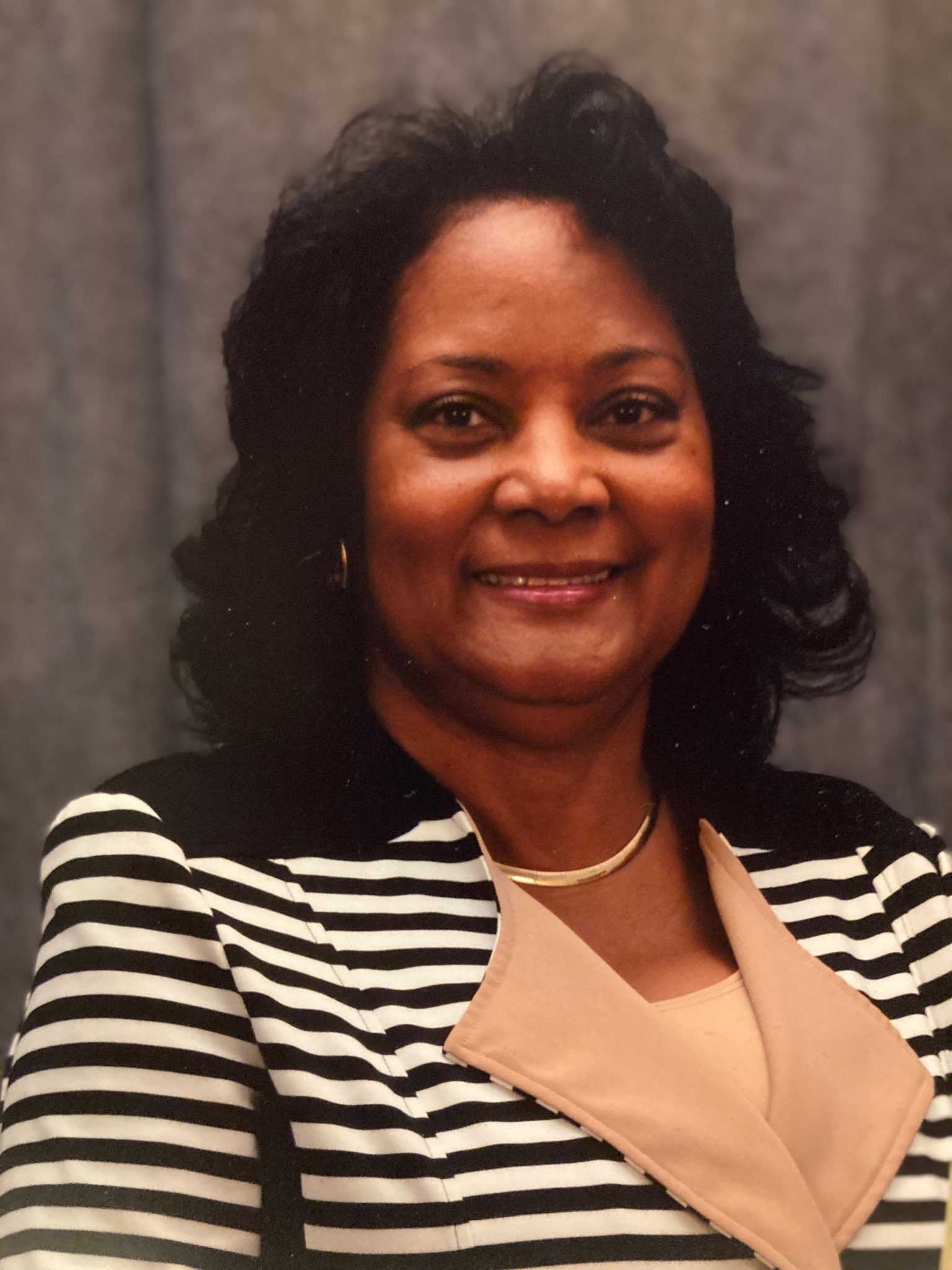 Dr. Pamela Huffman-DeVaughn, a Black woman, wearing a black-and-white striped blazer.