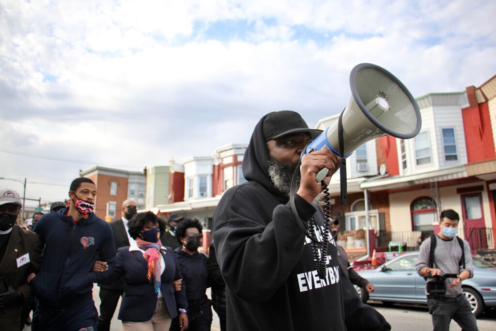 Image from iOS (192) Community activist Isaac Gardner leads a march on Locust Street demanding justice for Walter Wallace Jr., who was shot dead by police Monday. (Emma Lee/WHYY)