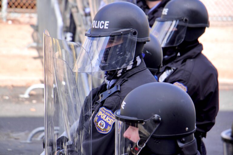 Police in riot gear meet protesters at 54th and Pine streets, barring their progress East on Pine Street. (Emma Lee/WHYY)