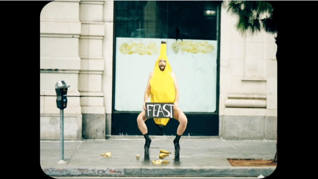 Screen Shot 2020-10-16 at 7.02.28 PM A person in a banana costume holding a sign that says