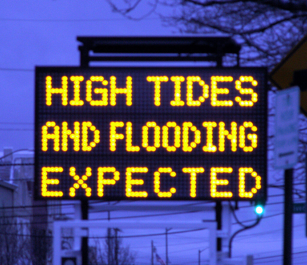 Sister72-is-licensed-under-CC-BY-2.0 A road sign warns of high tides and expected flooding