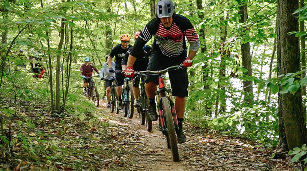 YOK_10.29 People biking on a trail in the woods