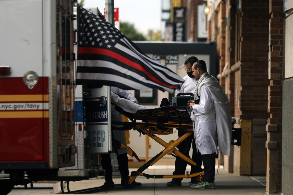 The number of people dying from COVID-19 since May 10th, is on average 50% higher than every other country in the study, adjusting for population size. A gurney is wheeled into an ambulance in New York