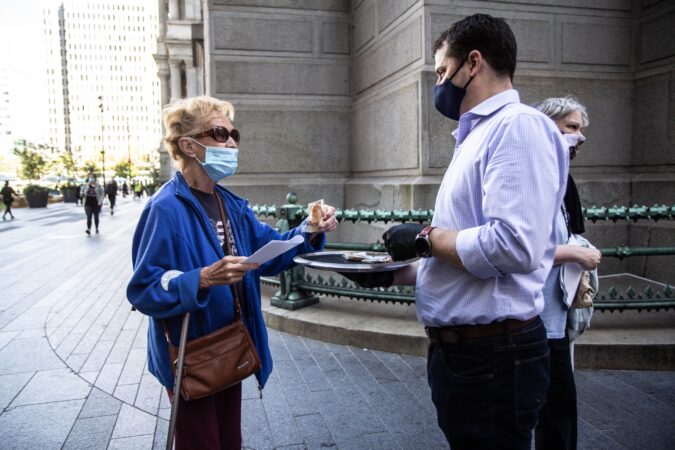 Society Hill resident Marion Kotulka receives a crossiant as she waits in line to vote at City Hall