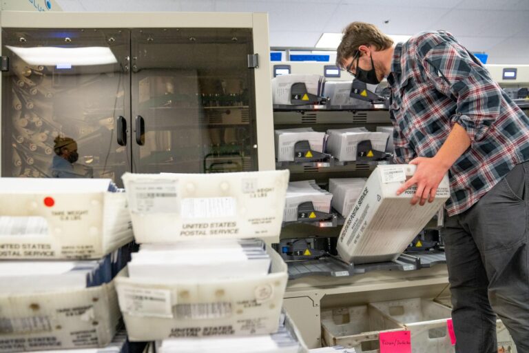 An elections worker organizes mail ballots in Chester County