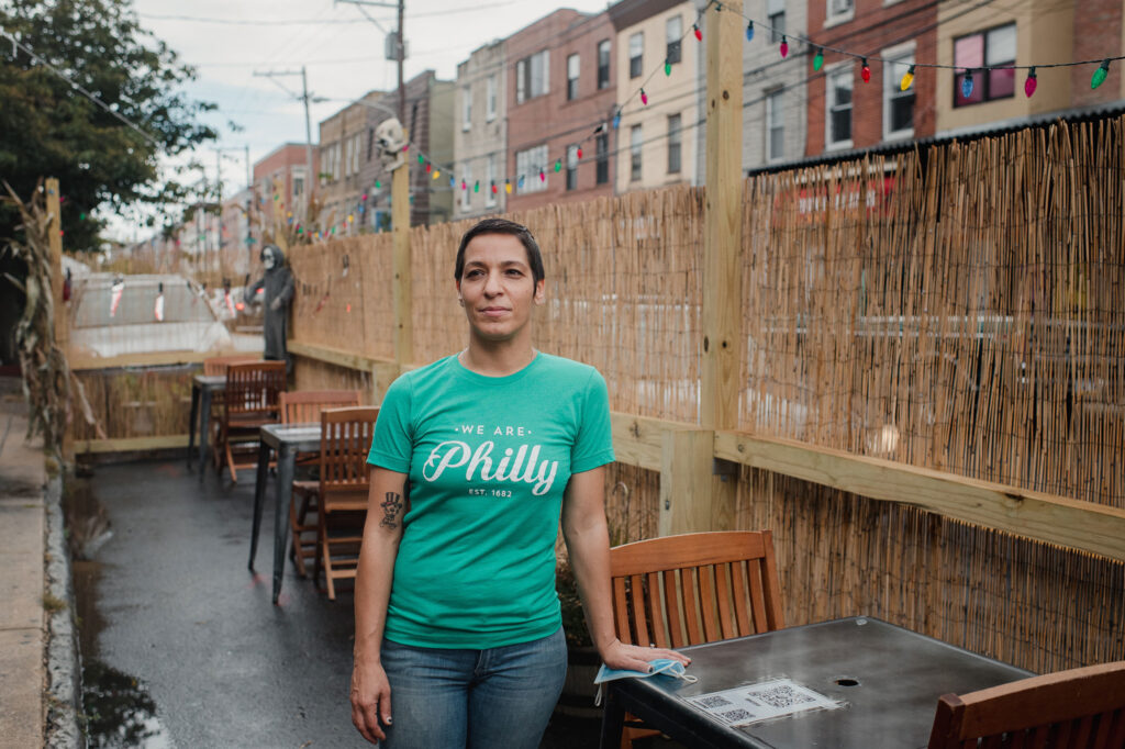 Danielle Renzulli, owner of 12 Steps Down Bar in Philadelphia, poses by the tables she has set up in what used to be parking spots. She was expecting some negative reactions from neighbors, given how valuable parking is in the area, but to her surprise, she received no complaints. Danielle Renzulli