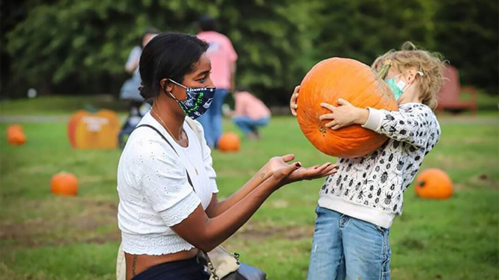 pumpkinpicking-snipesfarm A woman and child at a pumpkin patch wearing masks
