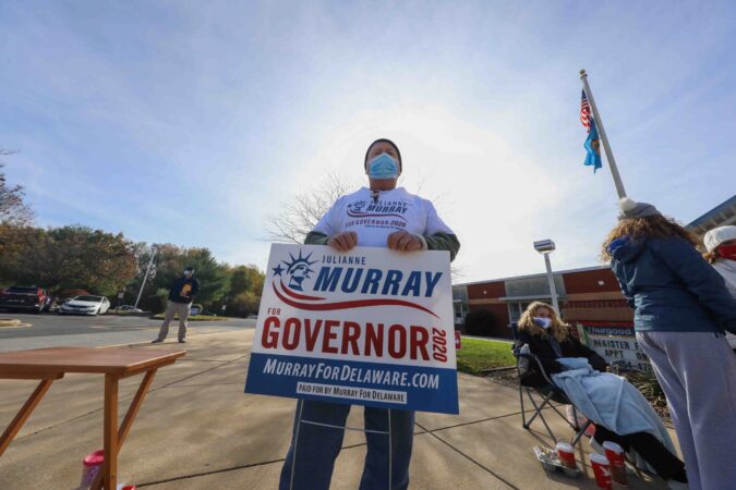A supporter stands in front of a polling location on election day, Tuesday, Nov. 03, 2020, at Thurgood Marshall elementary school in Newark, Del. (Saquan Stimpson for WHYY)