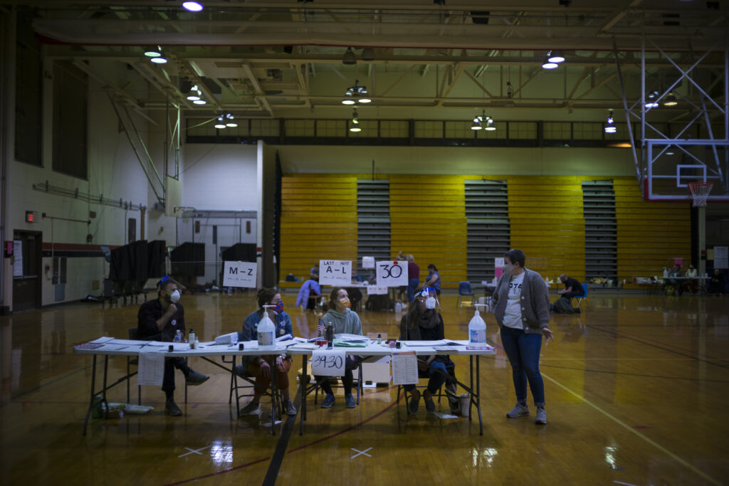 POLL WORKERS First-time election workers, seated, from left to right, Chris DiStasi, Kaitlin Irvine, Alicia Dlugos and Katie Phillips, end their day at South Philadelphia High School, a polling site on South Broad Street. (Alan Chin for WHYY)