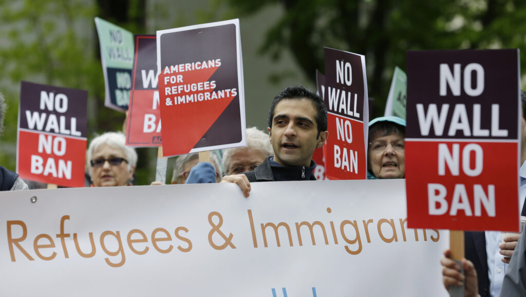 Refugees In Limbo FILE - In this May 15, 2017, file photo, protesters hold signs during a demonstration against President Donald Trump's revised travel ban, outside a federal courthouse in Seattle. Refugee advocates, including faith-based groups that President Donald Trump is courting in his re-election bid, called on Congress Thursday, Oct. 1, 2020, to halt his administration’s plans to slash the limit on refugees allowed into the U.S. to a record low, saying it goes against America’s values. (AP Photo/Ted S. Warren, File)