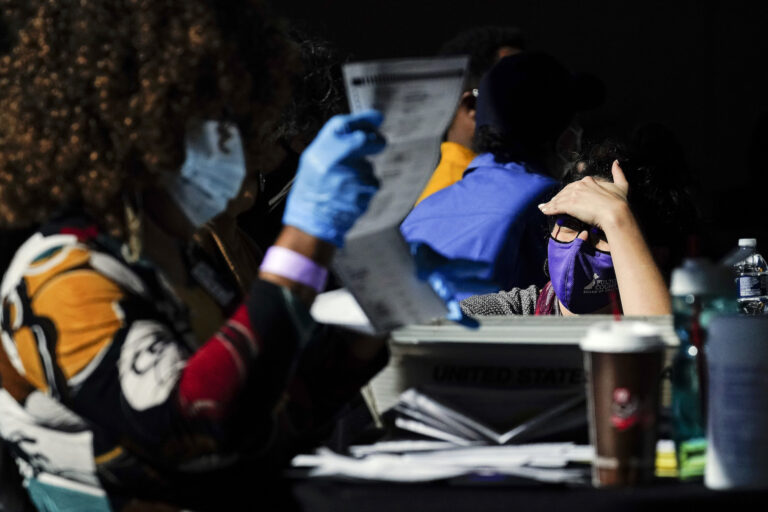 A election supervisor answer questions for the election workers as they count ballots at State Farm Arena on Thursday, Nov. 5, 2020, in Atlanta. (AP Photo/Brynn Anderson)