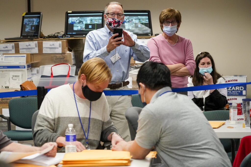 AP20311595756803-1920×1280 Republican canvas observer Ed White, center, and Democratic canvas observer Janne Kelhart, watch as Lehigh County workers count ballots as vote counting in the general election continues, Friday, Nov. 6, 2020, in Allentown, Pa. (Mary Altaffer/AP Photo)