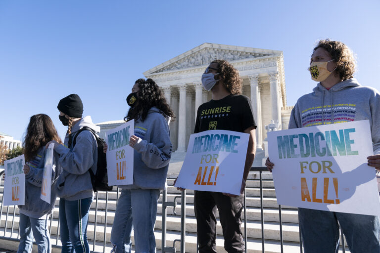 Demonstrators hold signs in front of the U.S. Supreme Court as arguments are heard about the Affordable Care Act Tuesday, Nov. 10, 2020, in Washington. (AP Photo/Alex Brandon)