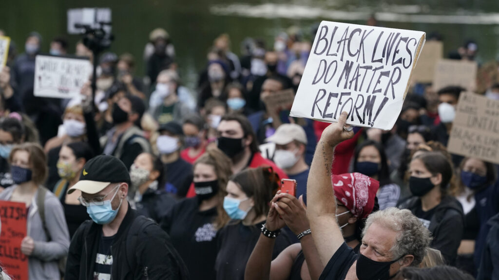 Racial Injustice Police Oversight In this Sept. 29, 2020, file photo, a man holds a sign during a protest, in Cleveland. (AP Photo/Tony Dejak)