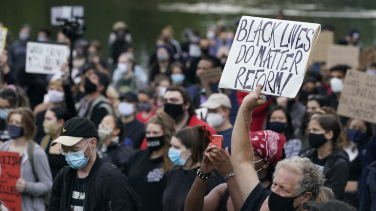 In this Sept. 29, 2020, file photo, a man holds a sign during a protest, in Cleveland. (AP Photo/Tony Dejak)