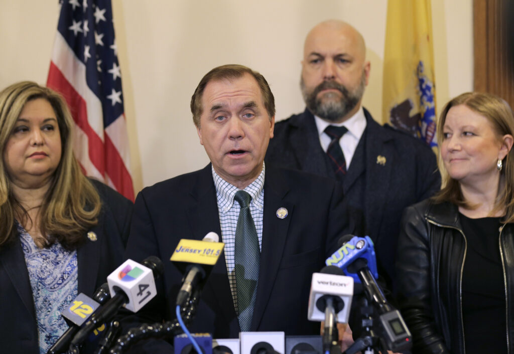 In this March 25, 2019 file photo, Assembly Speaker Craig Coughlin, center, speaks to reporters in Trenton, N.J. (AP Photo/Seth Wenig)
