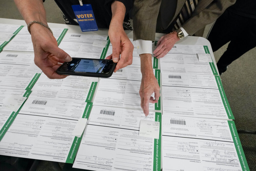a canvas observer photographs Lehigh County provisional ballots as vote counting in the general election continues in Allentown, Pa.