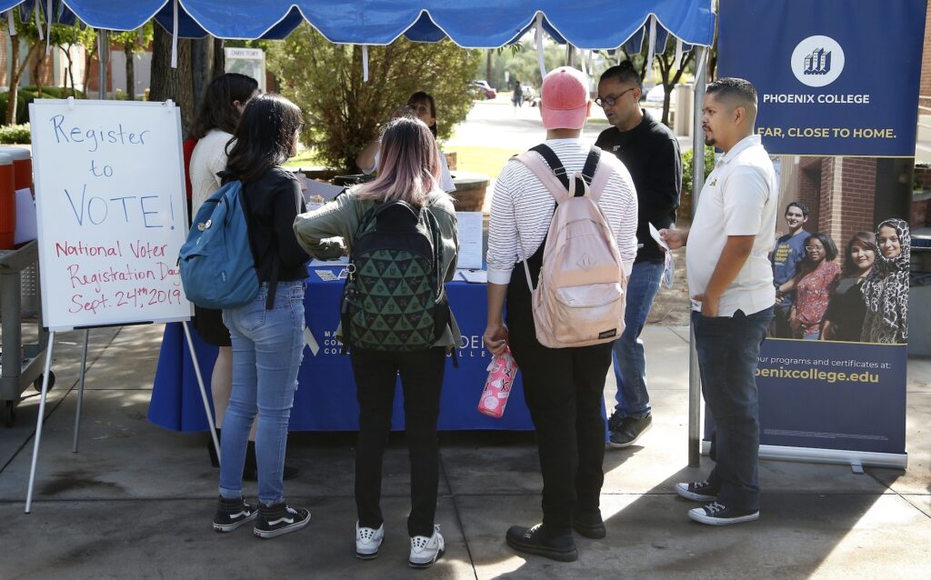 Election 2020-Arizona Latinos In this Sept. 24, 2019 file photo students at Phoenix College gather to fill out voter registration forms on National Voter Registration Day on campus, in Phoenix. (AP Photo/Ross D. Franklin)
