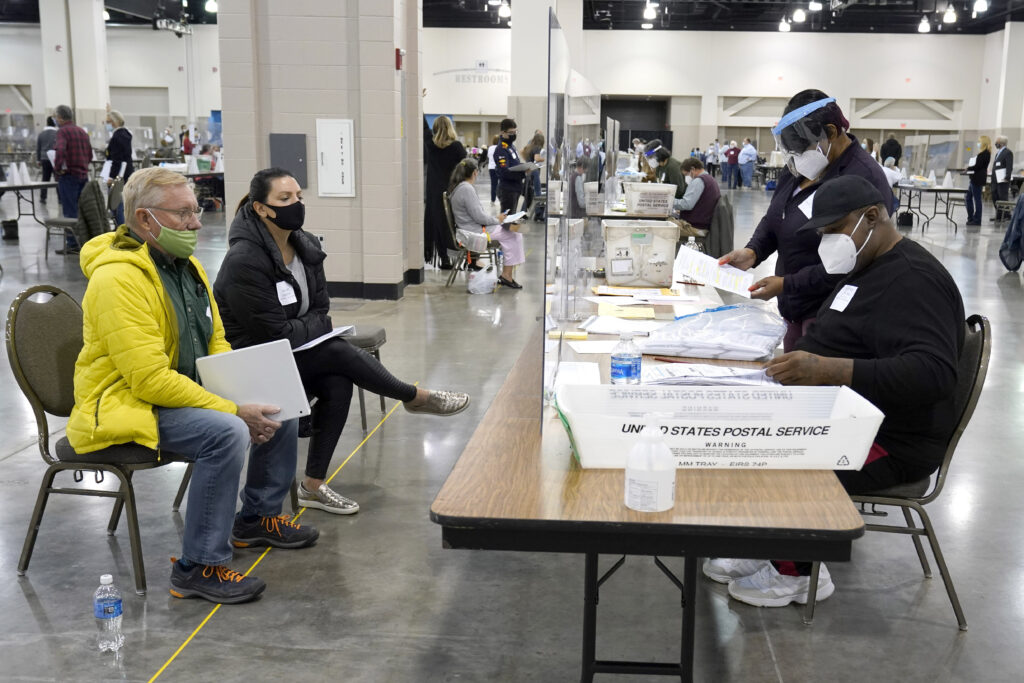 Election 2020-Wisconsin-Recount FILE - Election workers, right, verify ballots as recount observers, left, watch during a Milwaukee hand recount of presidential votes at the Wisconsin Center, Friday, Nov. 20, 2020, in Milwaukee. Wisconsin finished a partial recount of its presidential results on Sunday, Nov. 29, 2020 confirming Democrat Joe Biden's victory over President Donald Trump in the key battleground state. Trump vowed to challenge the outcome in court. (AP Photo/Nam Y. Huh)