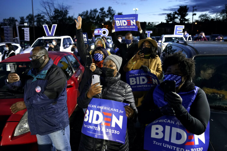 Supporters listen as Democratic presidential candidate former Vice President Joe Biden speaks at a drive-in campaign rally