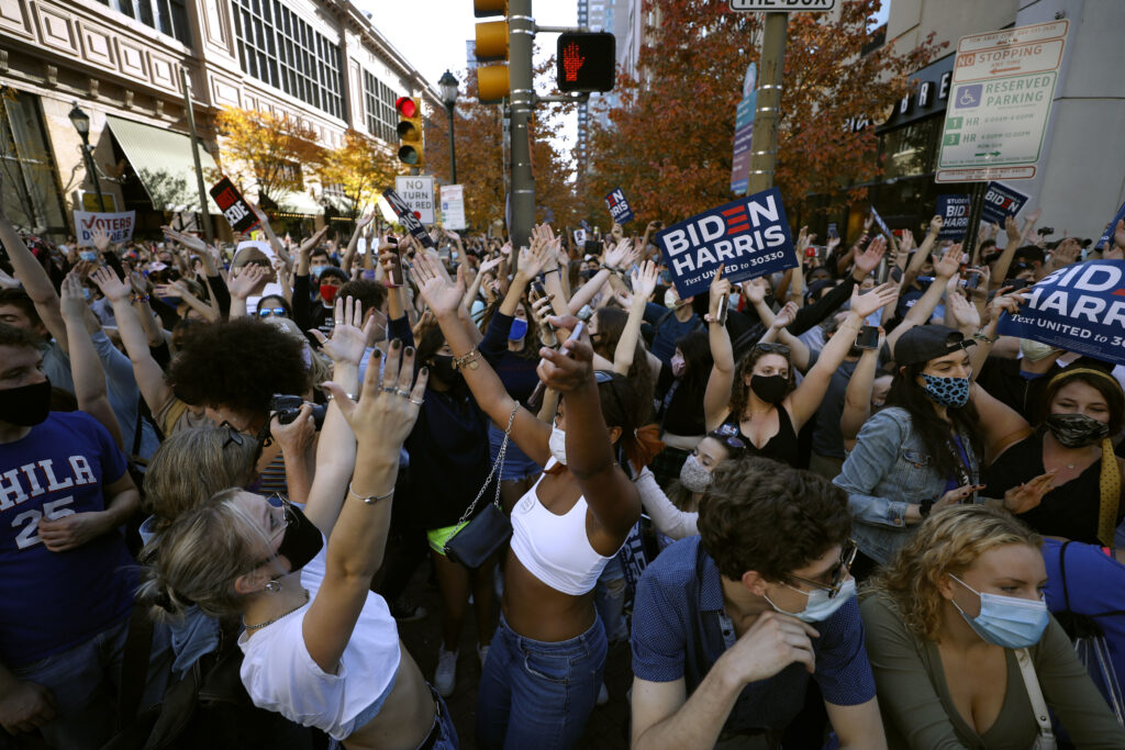 People dance as they celebrate outside the Pennsylvania Convention Center