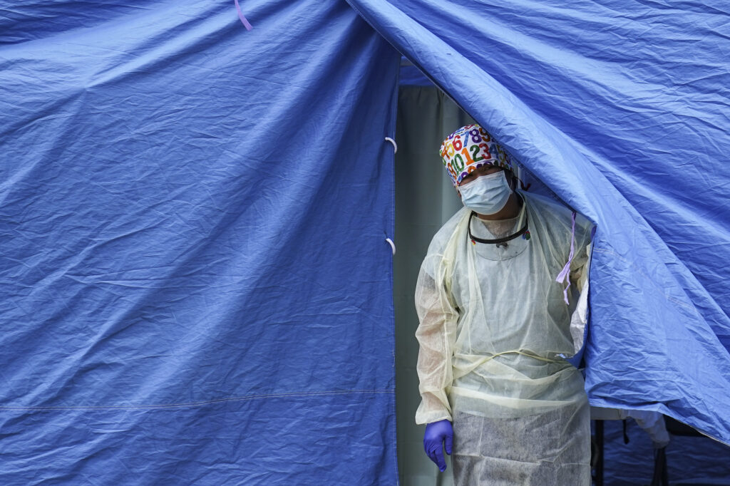 Virus Outbreak US Surge A medical worker operates a testing tent at a COVID-19 mobile testing site