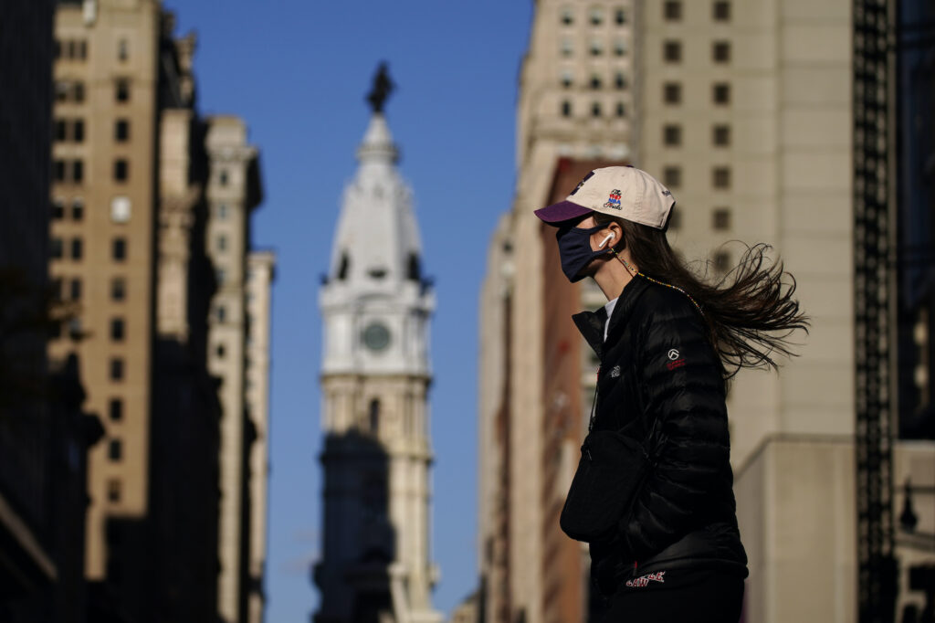 Virus Outbreak Pennsylvania A woman wearing a face mask crosses Broad Street