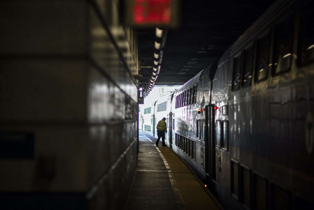 A train employee boards the commuter rail heading to Boston after waiting for passengers.