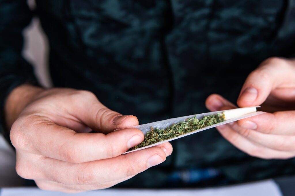 Drug Use. Close Up . Man Rolling A Marijuana Joint. Man Preparing And Rolling Marijuana Cannabis Joi A man rolls a marijuana joint. (Bigstock/cendeced)