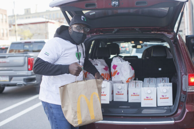 Dessie Hawk of Pull Up Neighbor hands out food to voters as they wait in line up at a polling place in Northern Liberties, Philadelphia in the midst of the Coronavirus pandemic to vote in person, Tuesday, November 3, 2020 in Philadelphia, PA. Pull Up Neighbor is handing out food and providing entrainment to voters at 20 different polling locations in Philadelphia.