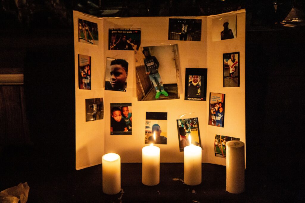 Photos of 12 year-old Sadeek Clark-Harrison and candles honor his life on his porch in Frankford. (Kimberly Paynter/WHYY)