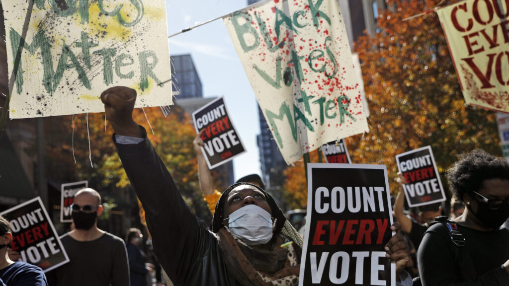 Zhanon Morales, 30, of Philadelphia, raises her fist during a Nov. 5 voting rights rally. President Trump’s campaign unsuccessfully used spurious claims of voter fraud to invalidate votes in Philadelphia and other largely Black cities. Zhanon Morales, 30, of Philadelphia, raises her fist during a Nov. 5 voting rights rally in Philadelphia.
(Rebecca Blackwell/AP)