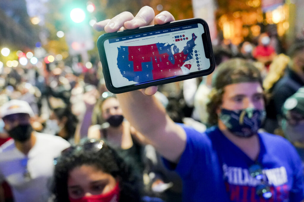 Election 2020 Protests Philadelphia A supporter of President-elect Joe Biden holds up his mobile phone to display the electoral college map outside the Philadelphia Convention Center