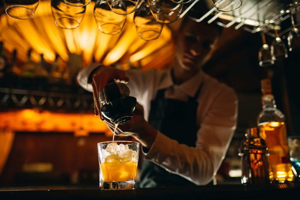 The Bartender Squeezes Citrus Juice Into A Cocktail. The Bartender Squeezes Citrus Juice Into A Cocktail.