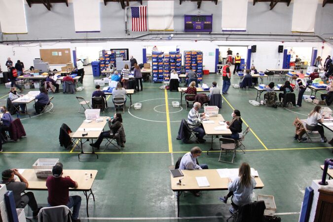 Chester County election workers sort, inspect, flatten and scan mail in ballots at the West Chester University gym.