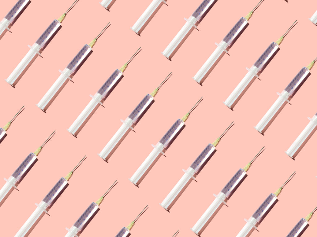 Repeated syringes on the pink background An illustration of syringes